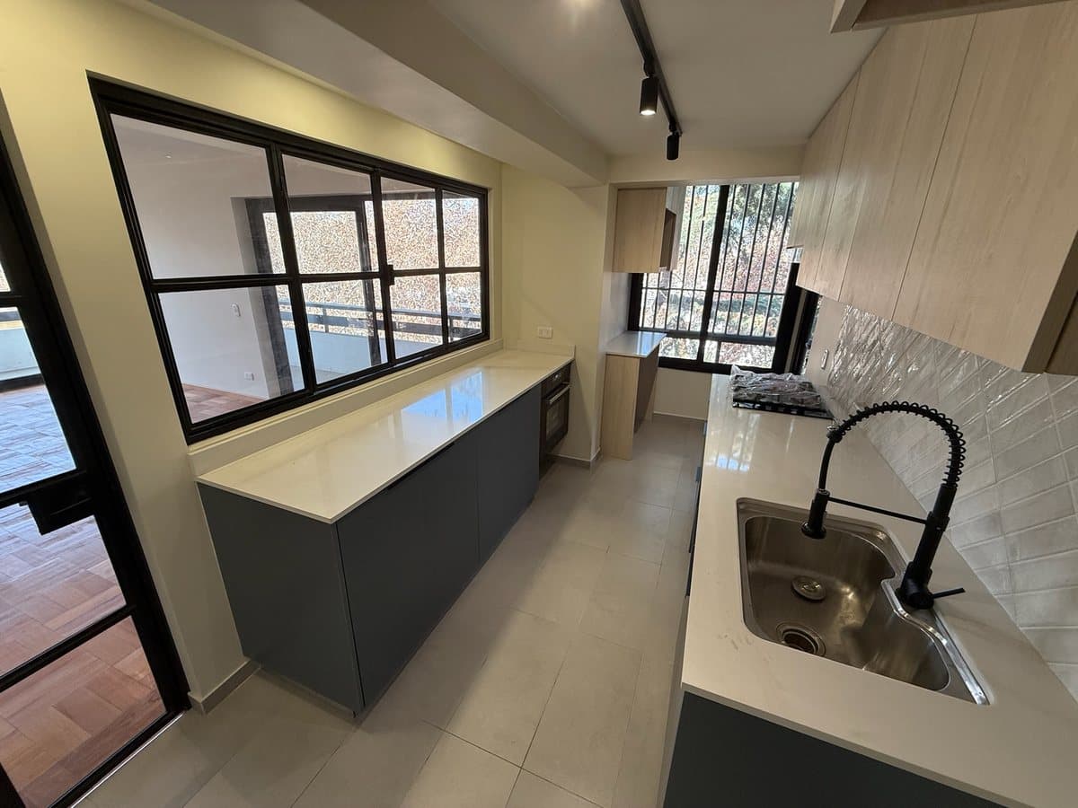 Cocina con mesón de cuarzo y muebles a medida