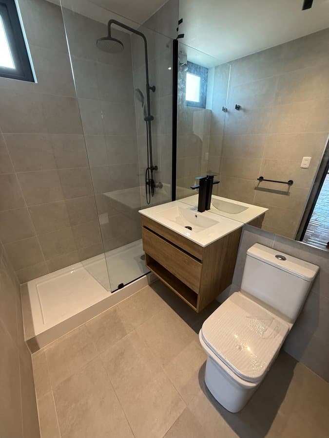 Baño principal con ducha y vanitorio en madera